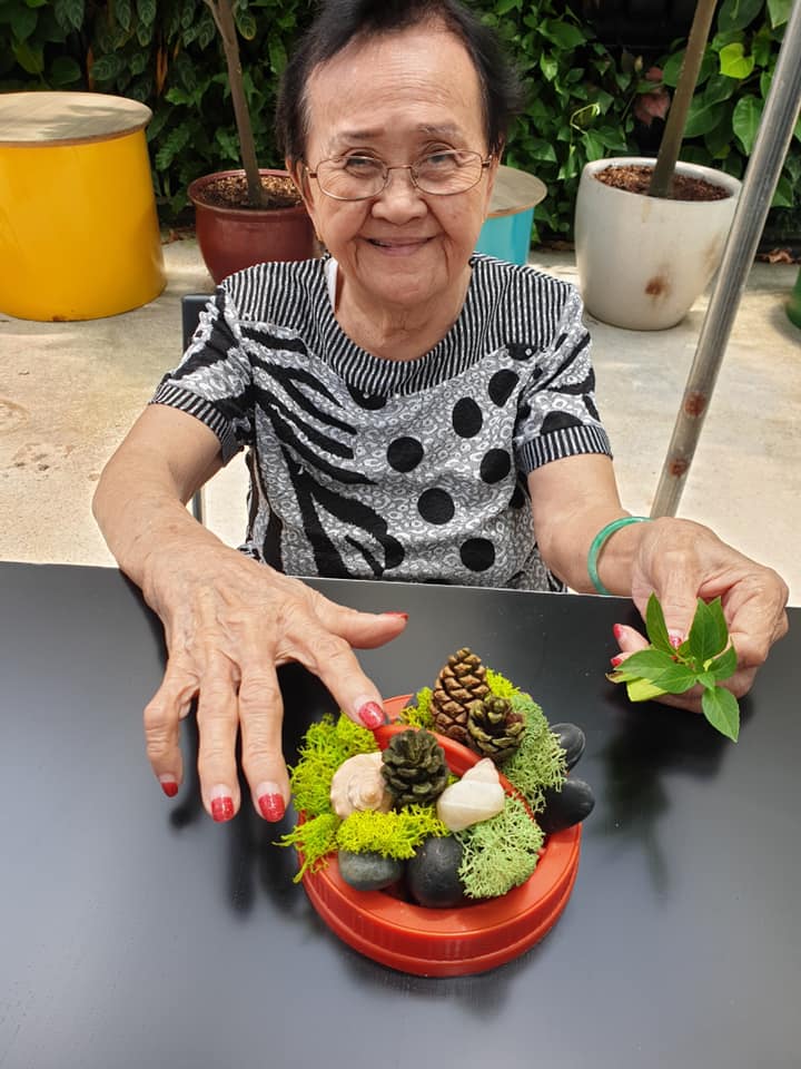 Elderly lady creating moss art | Apex Harmony Lodge | Greenology Singapore